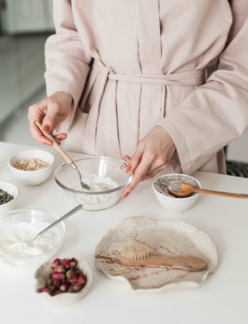 alt="DIY natural honey and oatmeal face cleanser in a glass bowl with a wooden spoon"